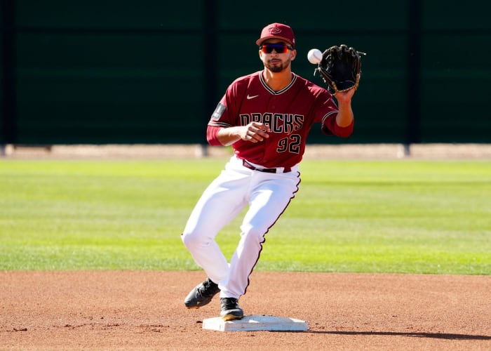 Diamondbacks infielder prospect Jordan Lawlar (92) receives a throw while standing on second base while doing Spring Training drills on a backfield.